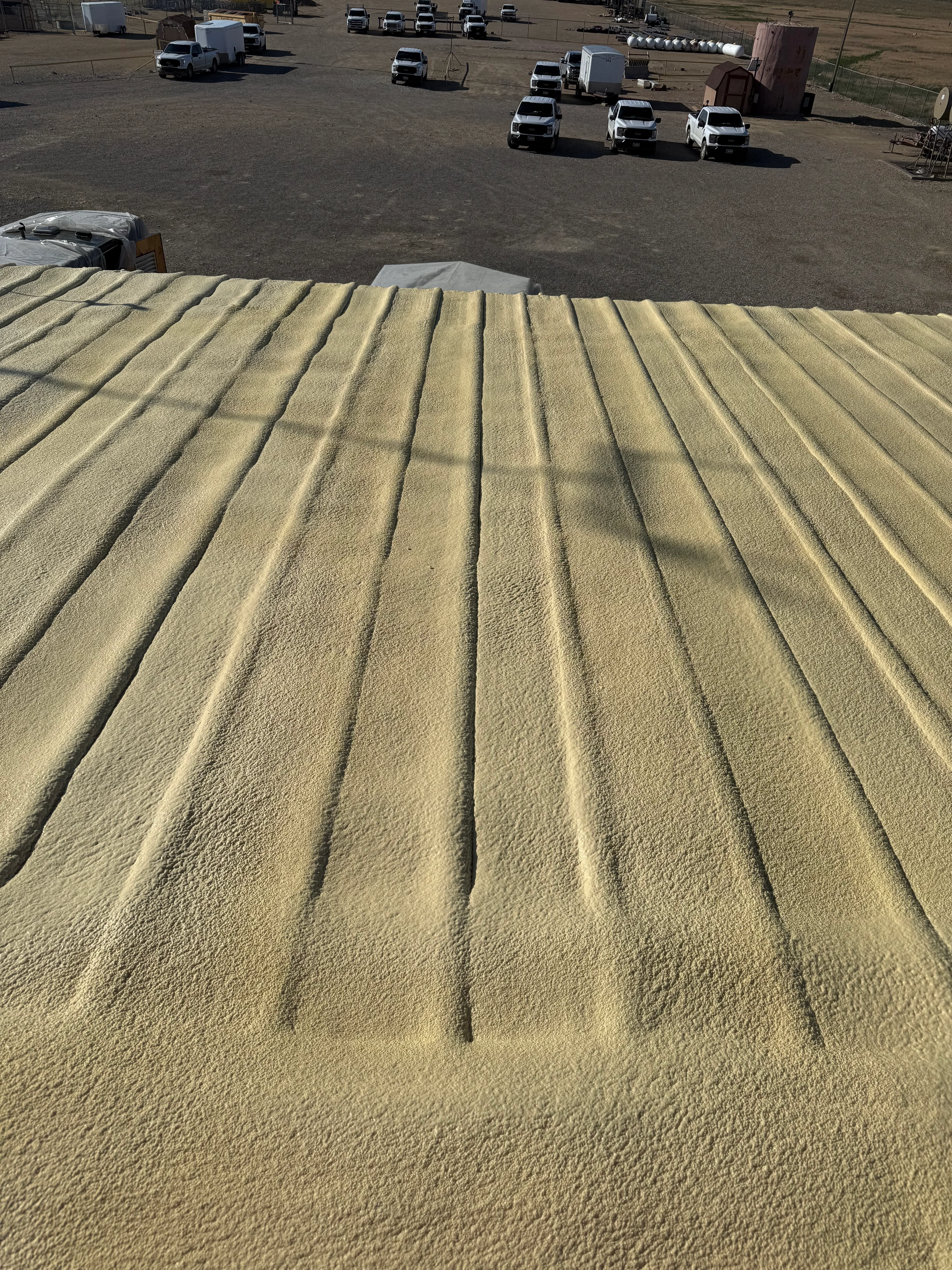 Spray foam insulation with uniform ridge pattern on commercial roof surface