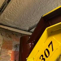 Yellow spray foam insulation applied to ceiling and wall surfaces during installation