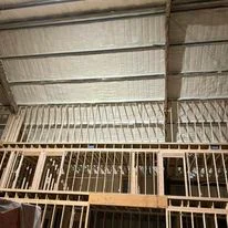 Attic insulation batts installed between wooden floor joists in commercial space
