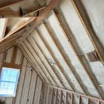 Attic insulation batts installed between wooden roof rafters in vaulted ceiling