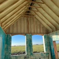Attic interior with installed insulation batts between rafters and pitched roof framing