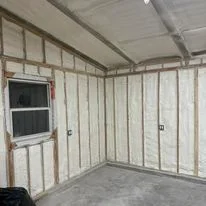 Interior wall framing with installed insulation batts between studs and window opening