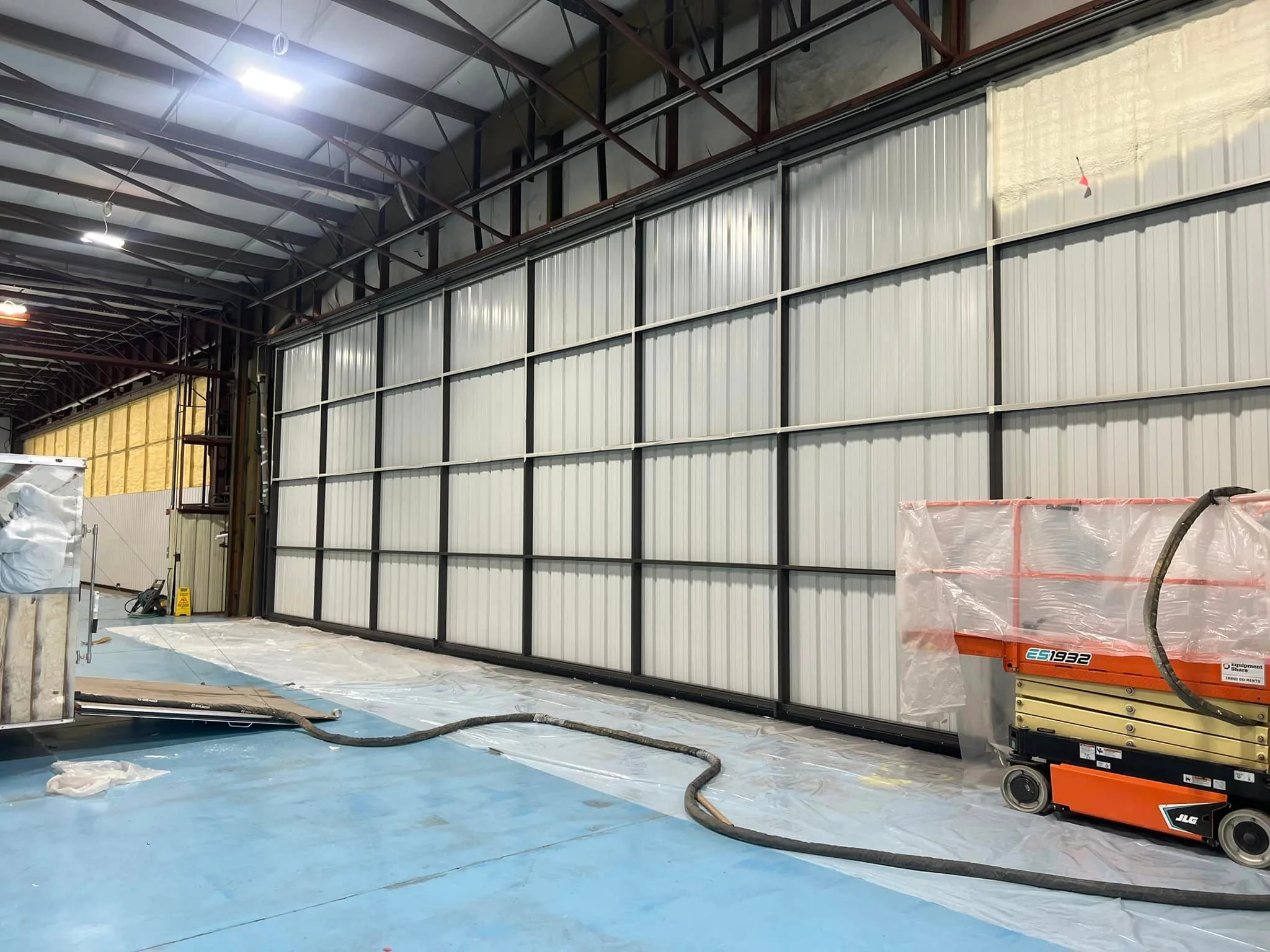 Industrial warehouse with white insulated metal wall panels and black steel framing