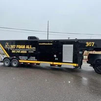 Black mobile spray foam insulation service trailer with 307 Foam All branding and equipment storage