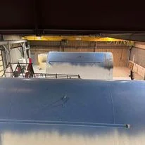 Industrial ceiling with spray foam insulation applied to overhead structure and beams