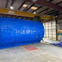 Blue spray foam insulation containment system in commercial warehouse during installation