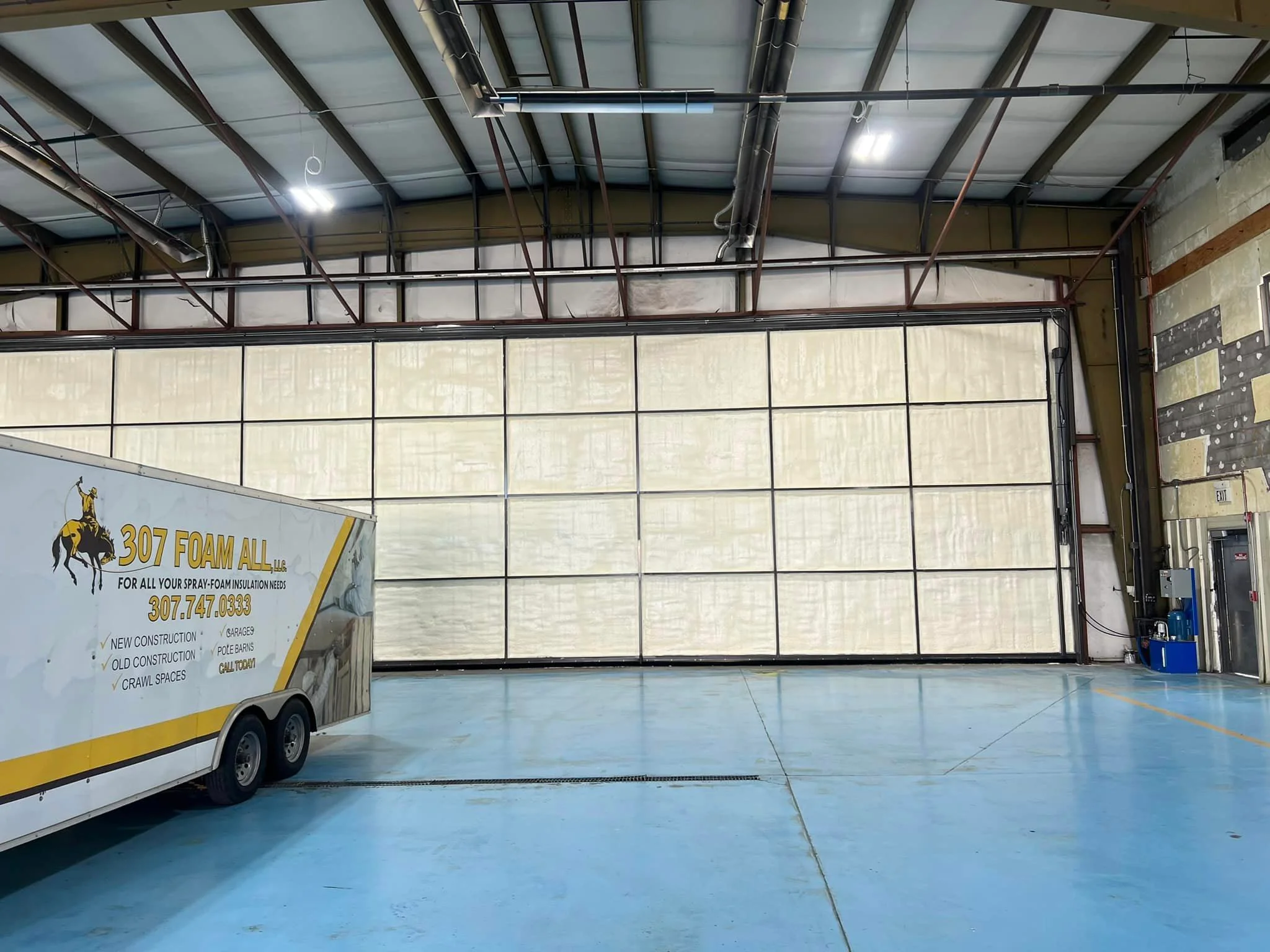 Commercial warehouse interior with spray foam insulation applied to full wall surface