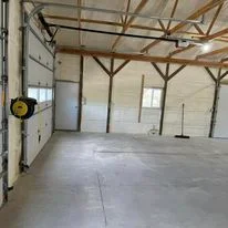 Interior of commercial garage with newly installed wall insulation and exposed wooden beam structure