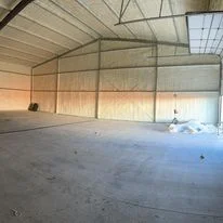 Empty commercial warehouse interior with metal frame structure and insulation materials installed
