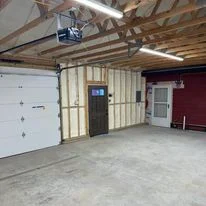 Garage interior with spray foam insulation applied to walls and ceiling framing
