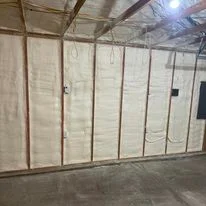 Spray foam insulation applied to interior warehouse walls in commercial building